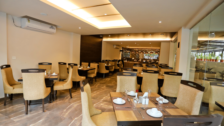 Dining area with tables and chairs neatly arranged at Amara Grand Baga, Goa.